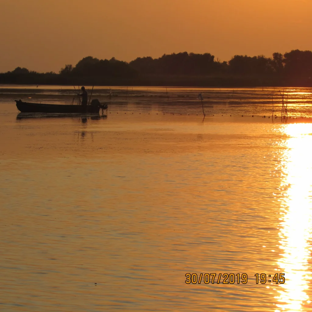 Apus de soare pe lac cu barcă de lemn