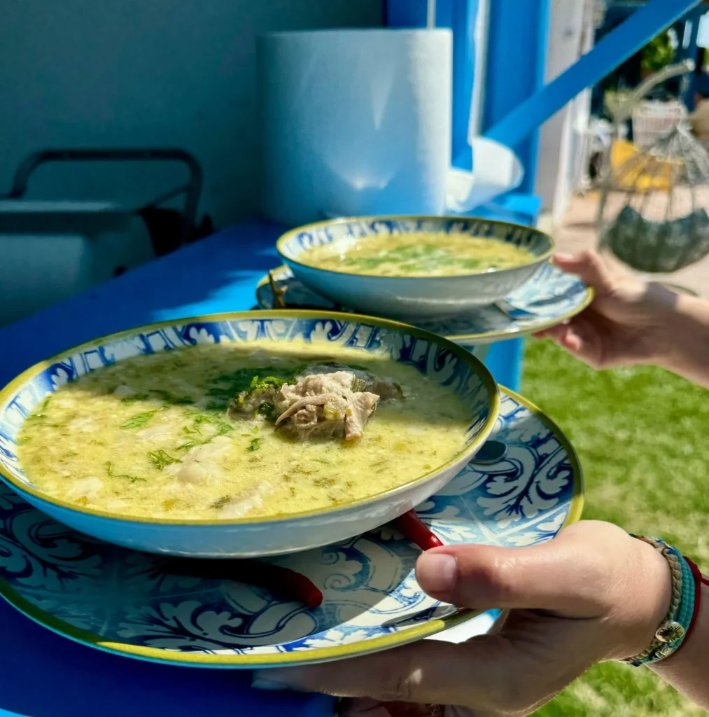 Supă tradițională servită în farfurii albastre decorative
