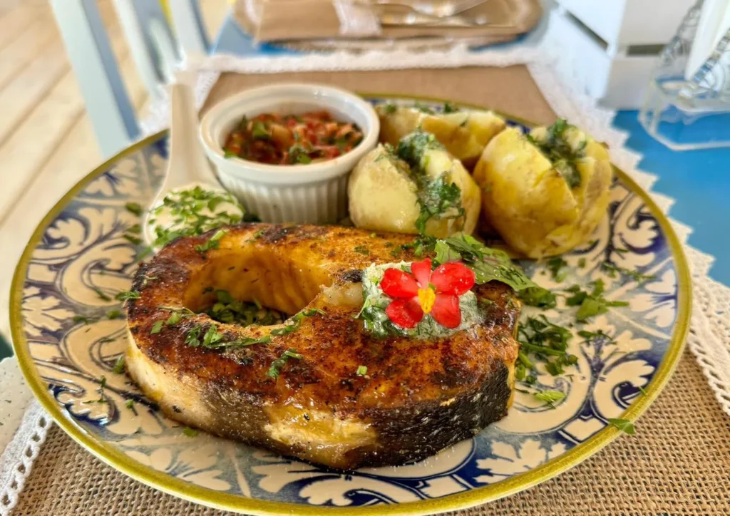 Pește prăjit cu cartofi și sos pe farfurie decorativă