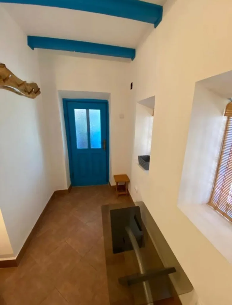 Hall with blue door and beams.