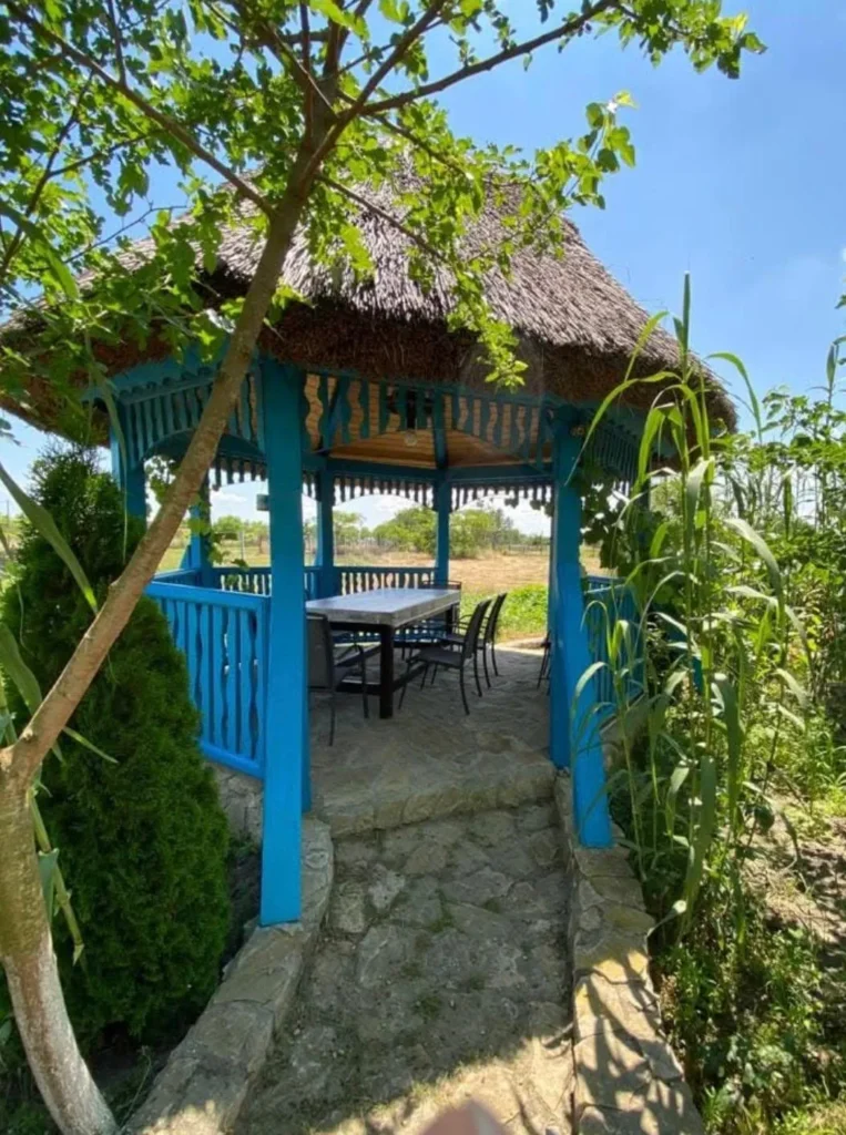Blue wooden gazebo in the garden in summer.